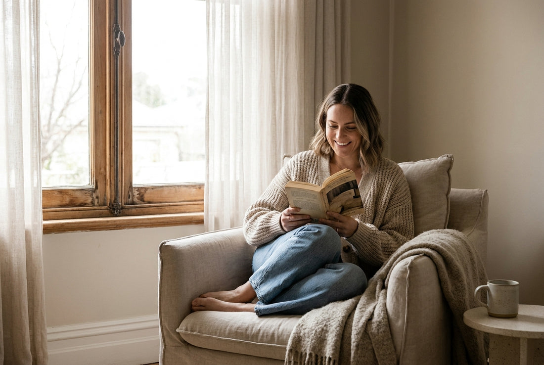 A woman reading calmly by a window at home